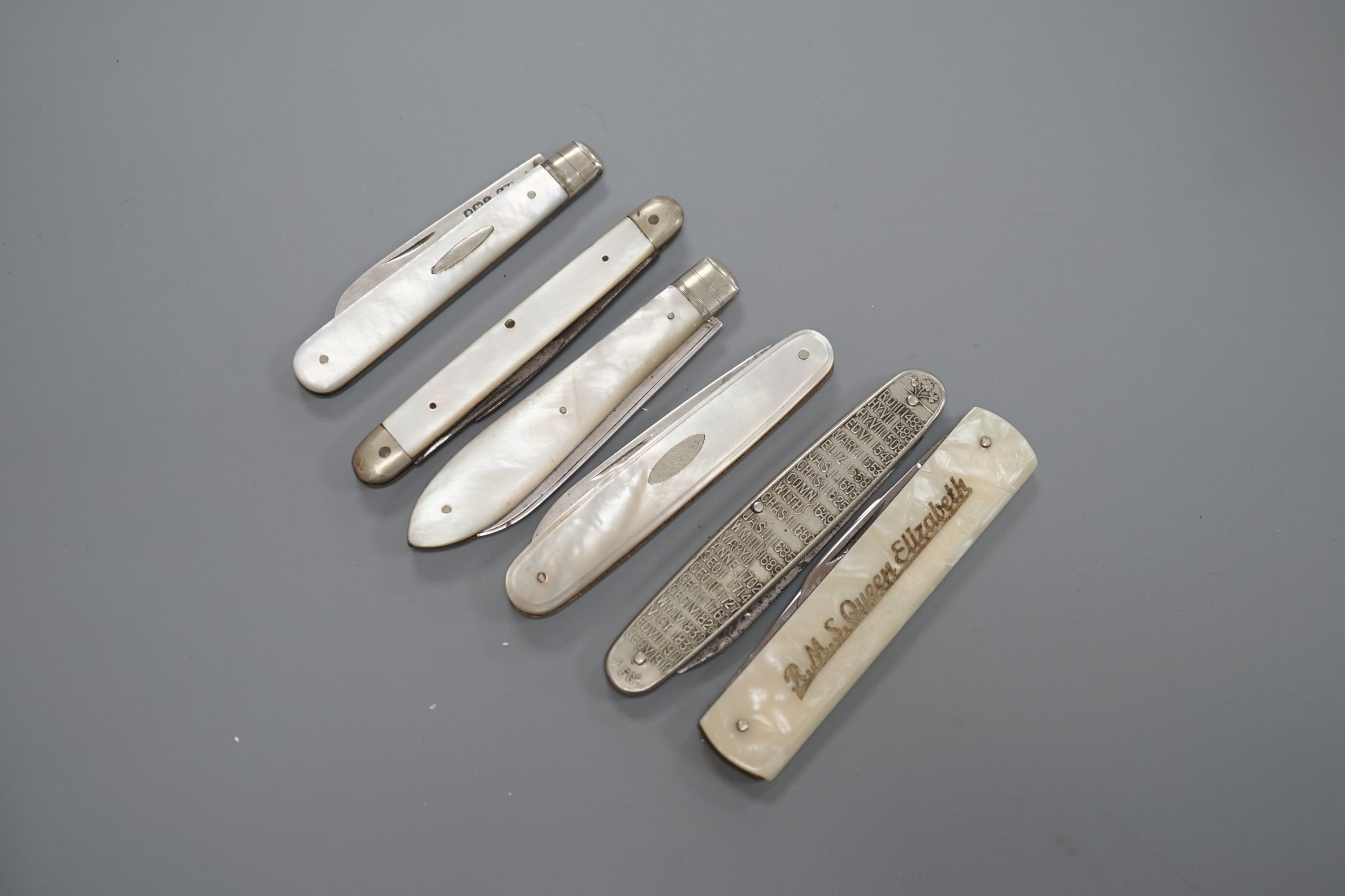 Three assorted mother of pearl mounted silver bladed fruit knives, one other penknife and two commemorative pocket knives.